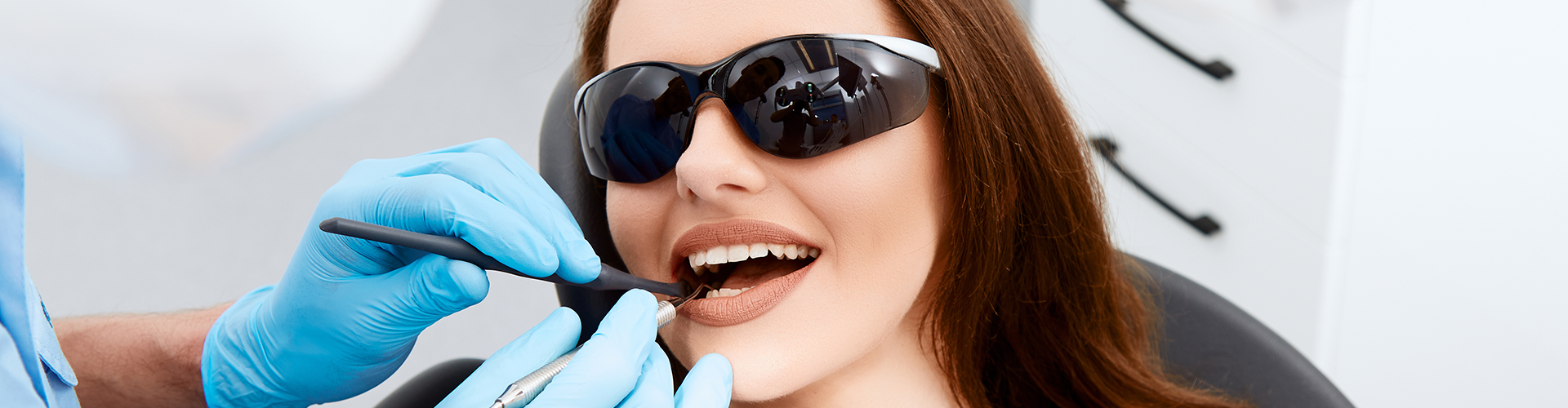 gloved hands holding dental tool in patient's mouth